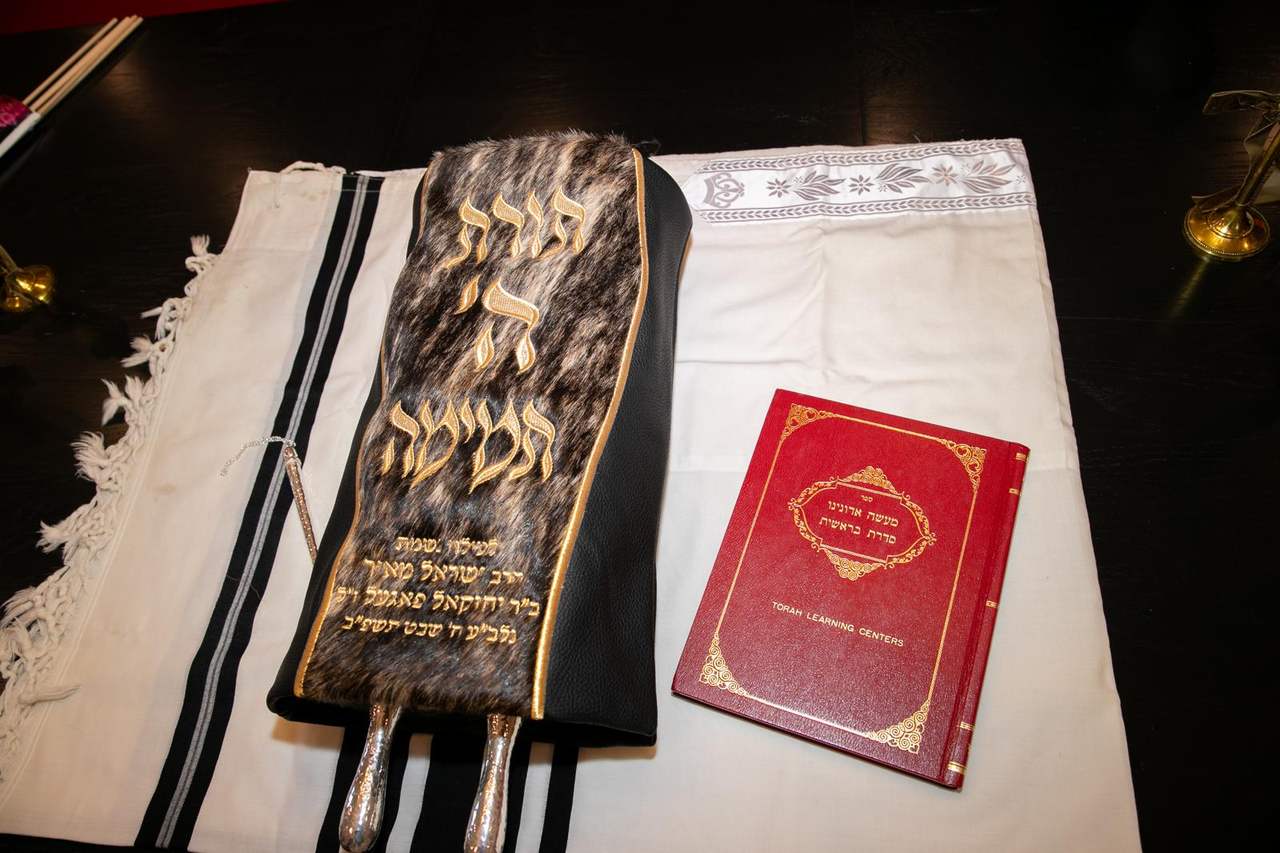 The Sefer Torah’s mantle resting beside a copy of Torah Learning Centers, the sefer written by Rabbi Yisroel Meir Vogel