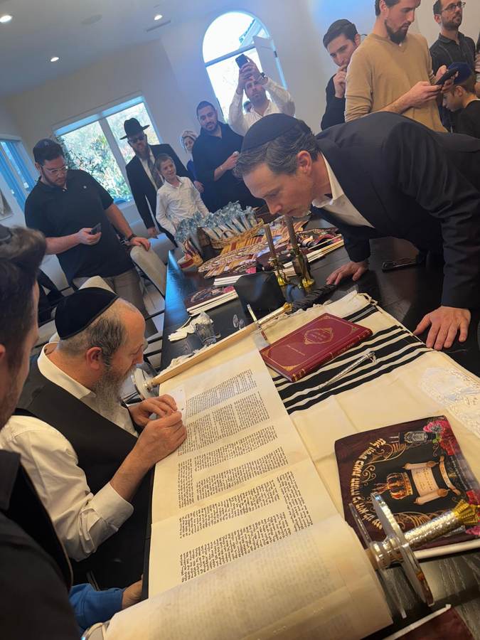 The sofer at work as guests look on
